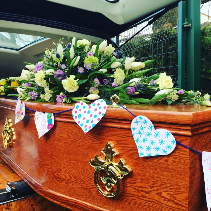 Coffin-oak-wooden-brass-handles-buntin-traditional-modern-personalised-celebration-yellow-purple-coffin-spray-flowers-hearse